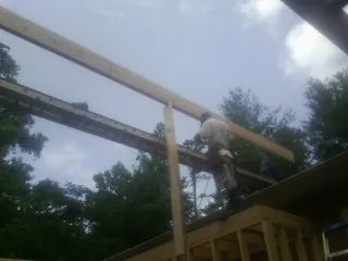 Carpenter setting a ridge beam over a new addition frame — Ice Dam Removal by Roofing Brothers in Joplin