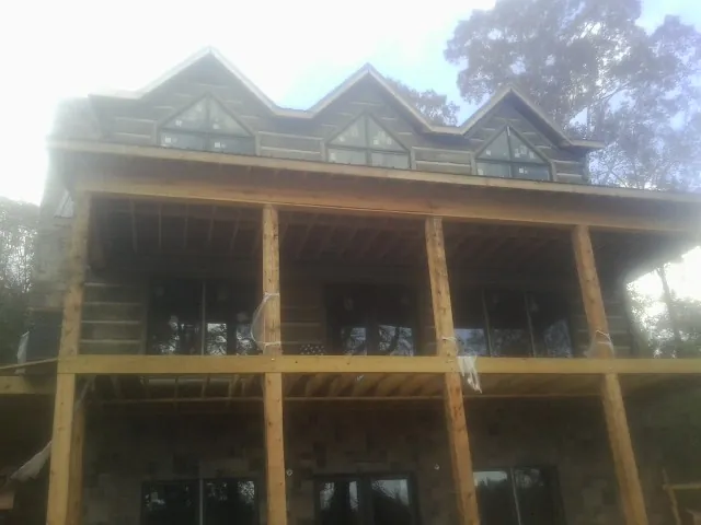 Dormers and porch framing on a large log home under construction — Roof Coating work by our crew in Joplin