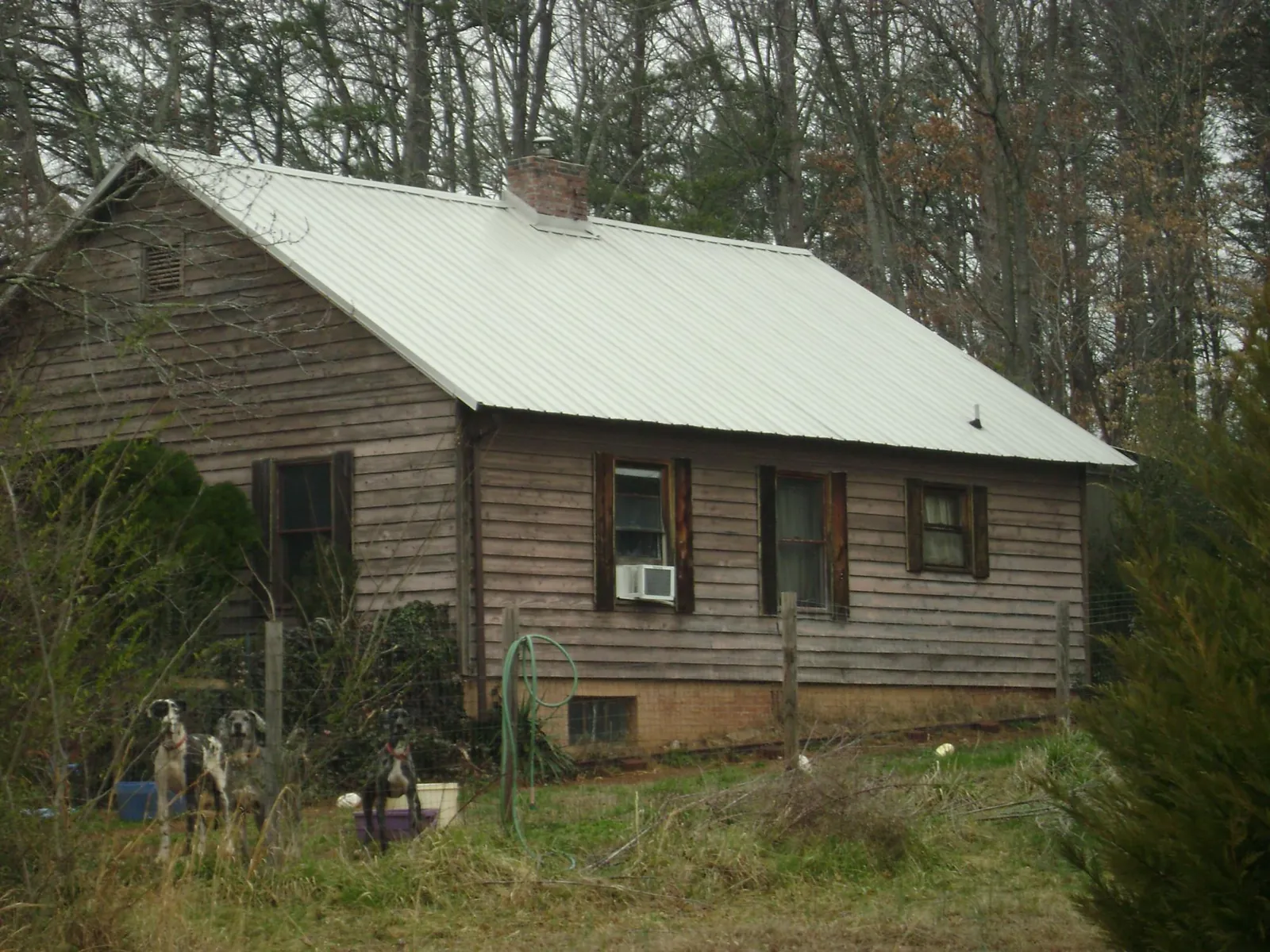 White metal roof on an old wood sided farmhouse, from a Metal Roof Installation job in Joplin